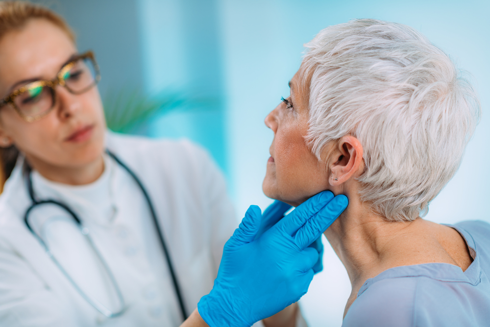 doctor examines thyroid