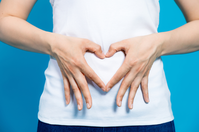 woman holding heart over gut